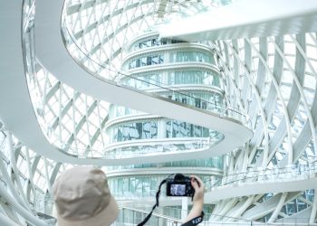 a woman taking a picture of a building with a camera