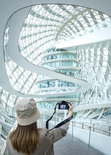 a woman taking a picture of a building with a camera